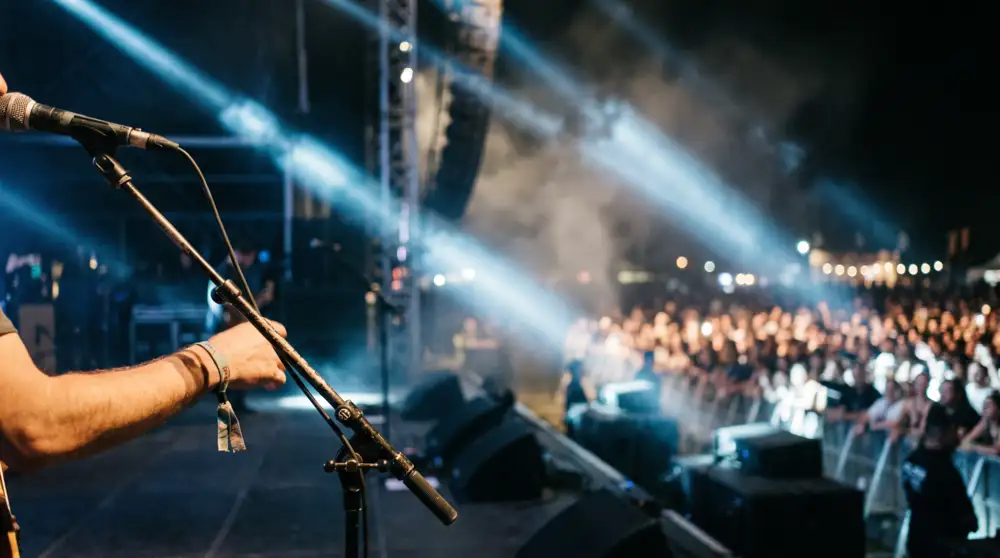 Concert stage technician at a microphone facing the crowd