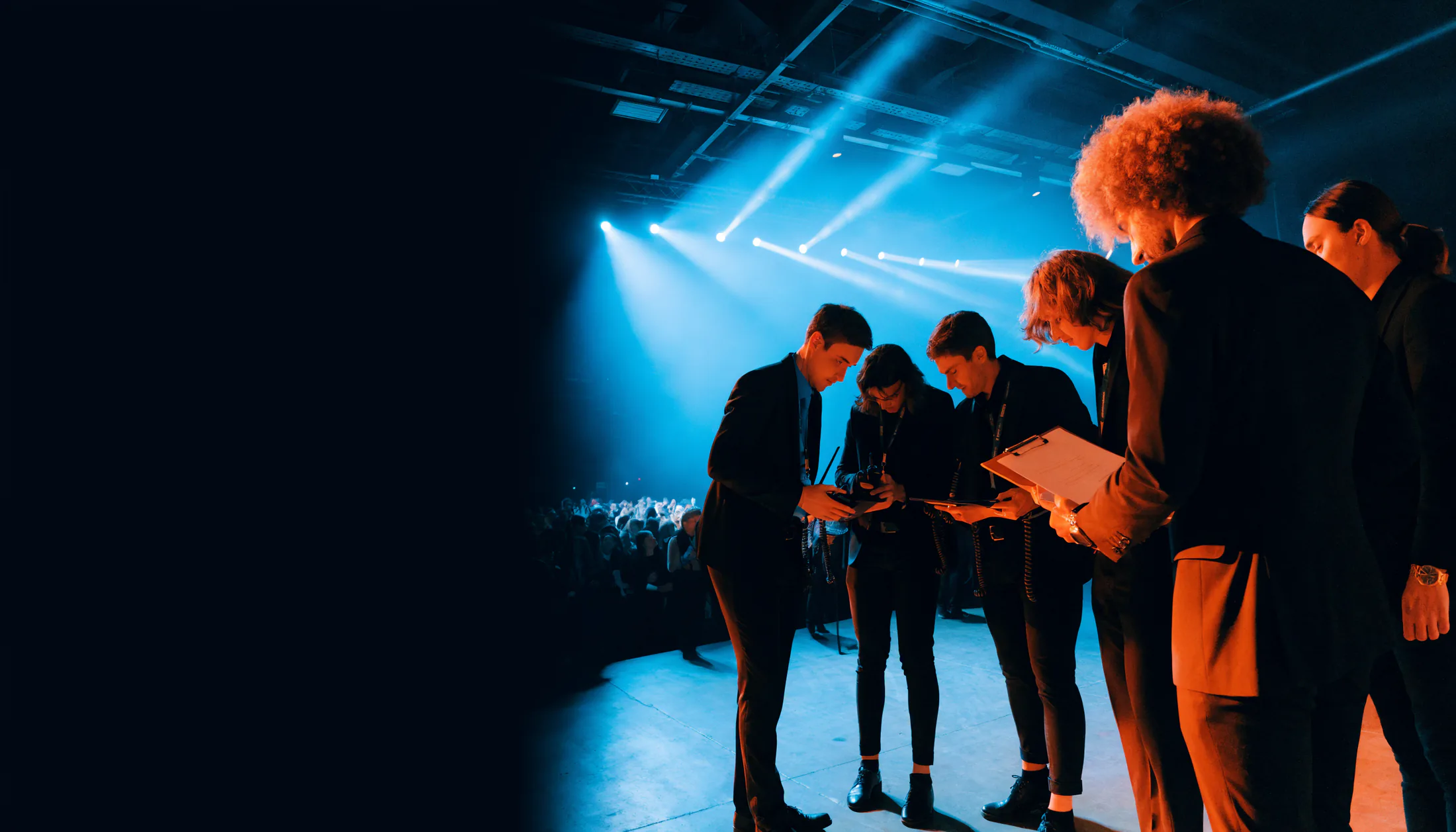 Concert event operations crew reviewing the show plan beside a live stage