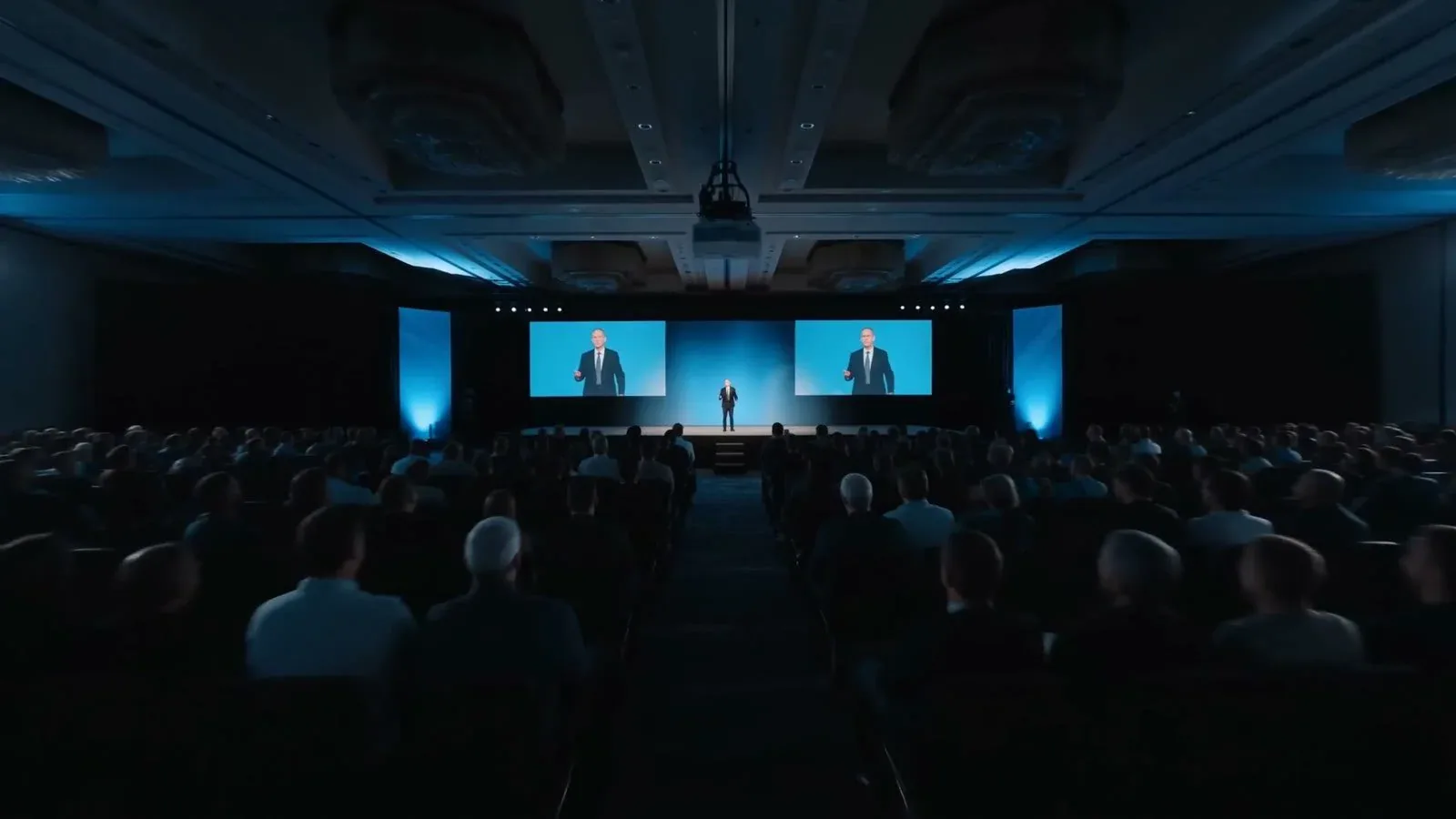 Conference keynote audience facing a lit stage